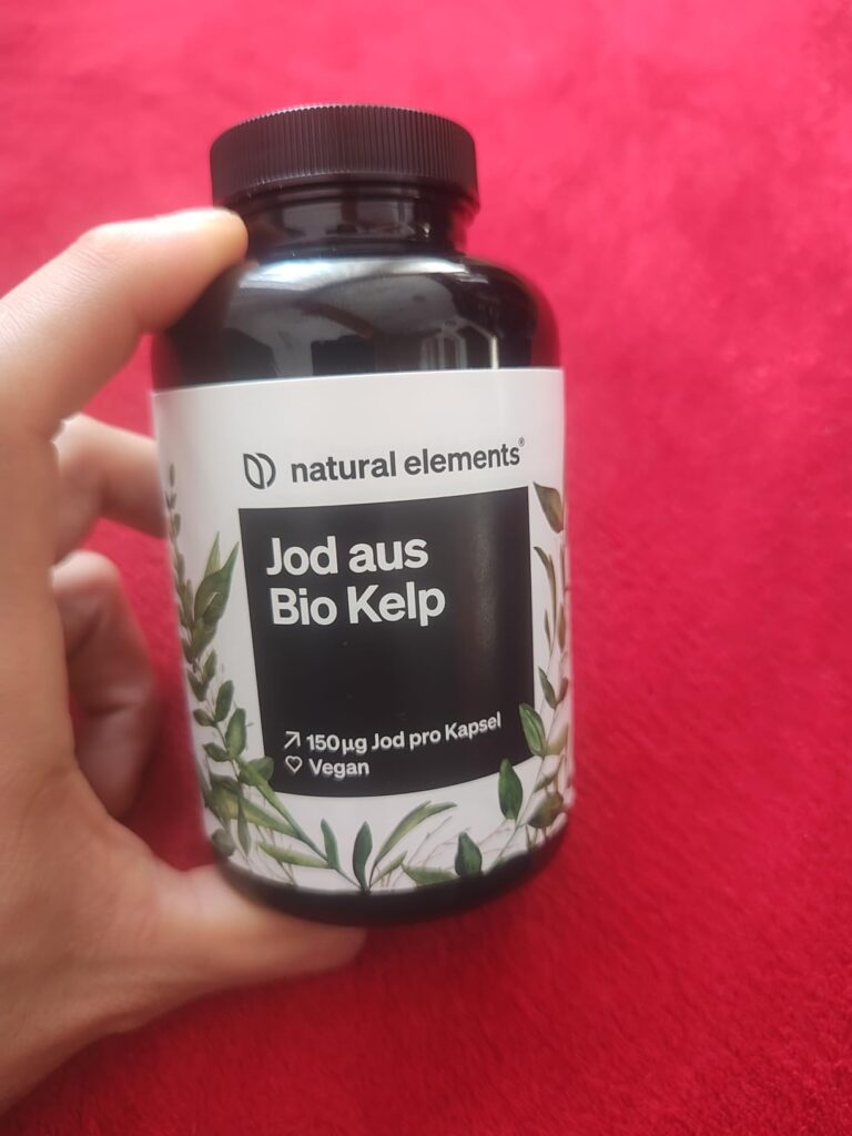 Bouteille de compléments alimentaires vue de face, tenue par une main