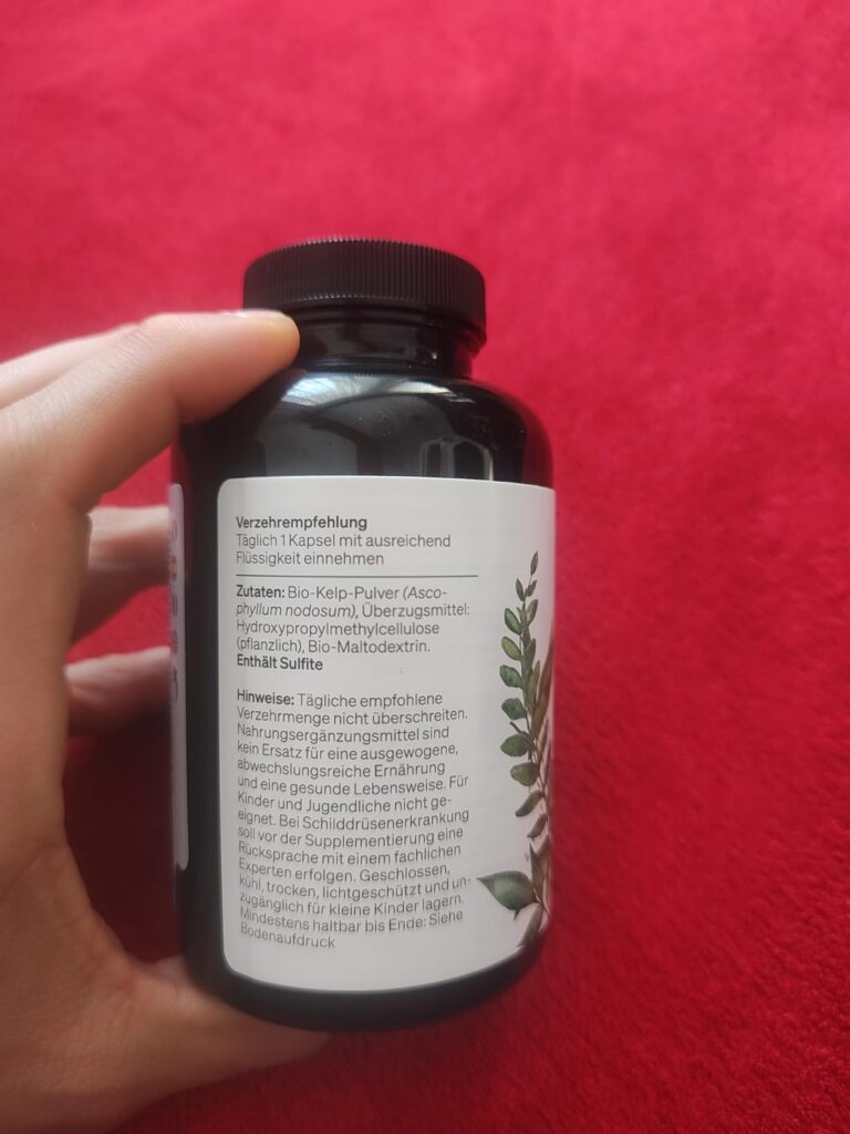 Bouteille de compléments alimentaires vue de profil, tenue par une main. L'étiquette indique des informations sur la composit...