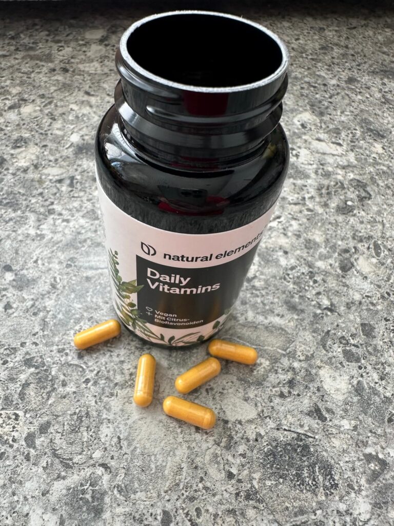 Bouteille de vitamines sur une table avec quelques gélules à côté