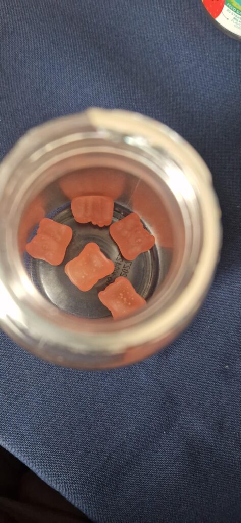 Vue de l'intérieur du flacon montrant les gummies en forme d'étoile.