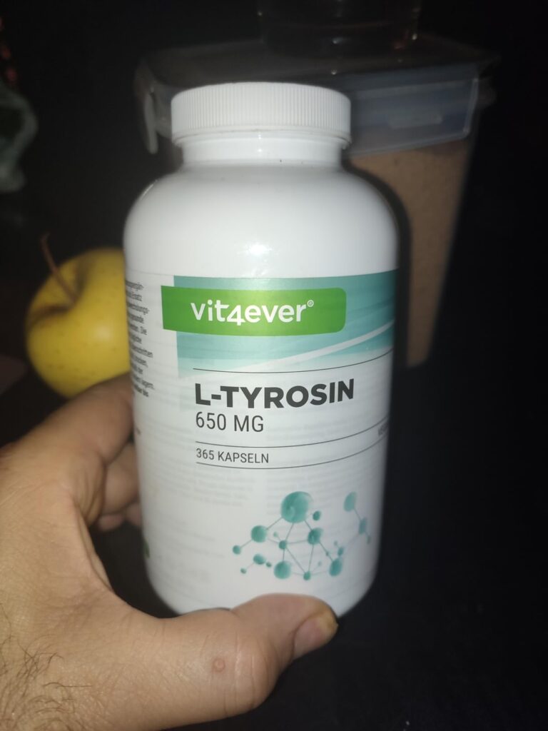 Bouteille de L-Tyrosine de la marque Vit4ever, tenue dans la main. L'étiquette indique le dosage et le nom du produit. Une po...