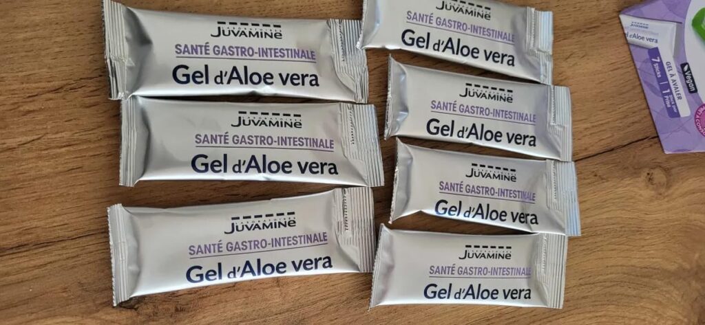 Plusieurs sachets de Gel d'Aloe vera JuvaMine posés sur une table en bois.