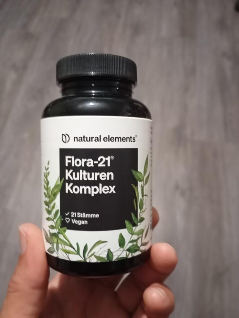 Flacon de probiotiques tenu dans une main
