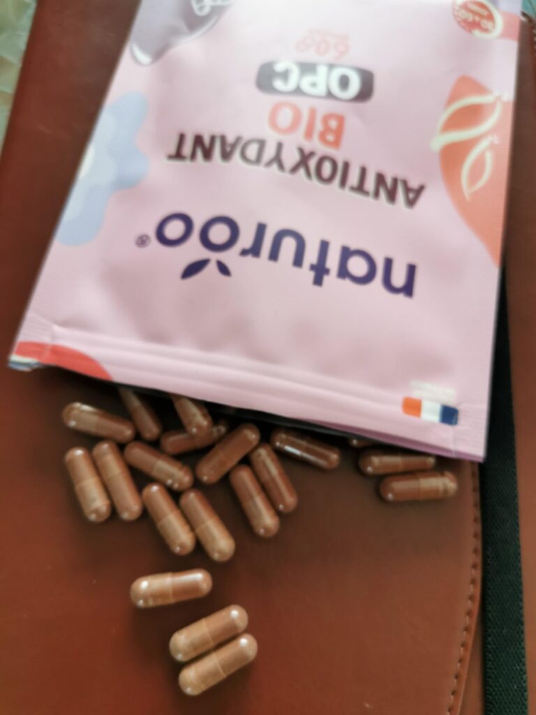 Vue des gélules étalées devant le sachet posé sur une table.