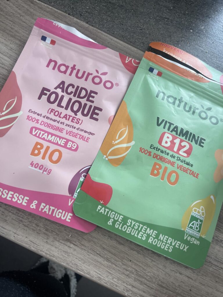 Deux sachets de compléments alimentaires Naturoo, l'un pour l'acide folique (rose), l'autre pour la vitamine B12 (vert).