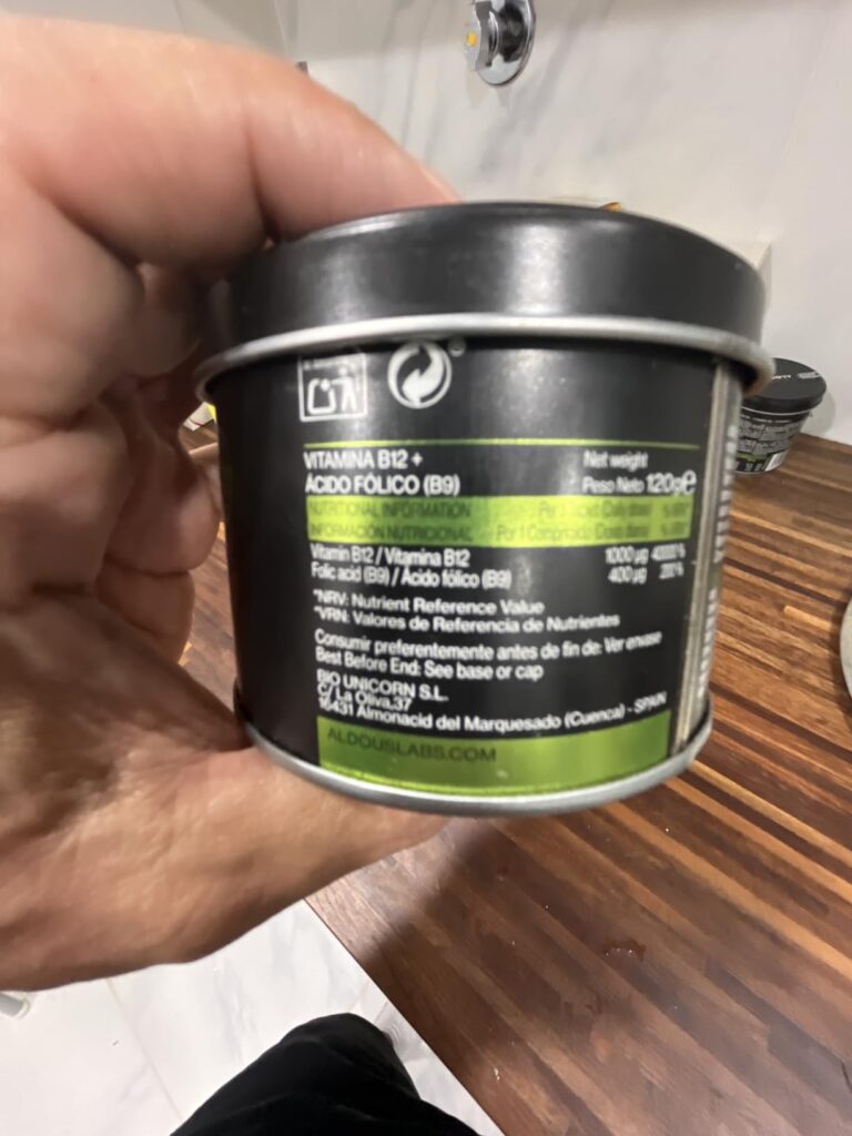 Boîte de complément alimentaire, vue de côté, tenue à la main.