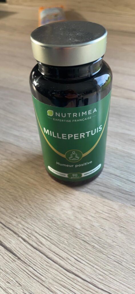 Flacon de Millepertuis Nutrimea posé sur un parquet en bois.