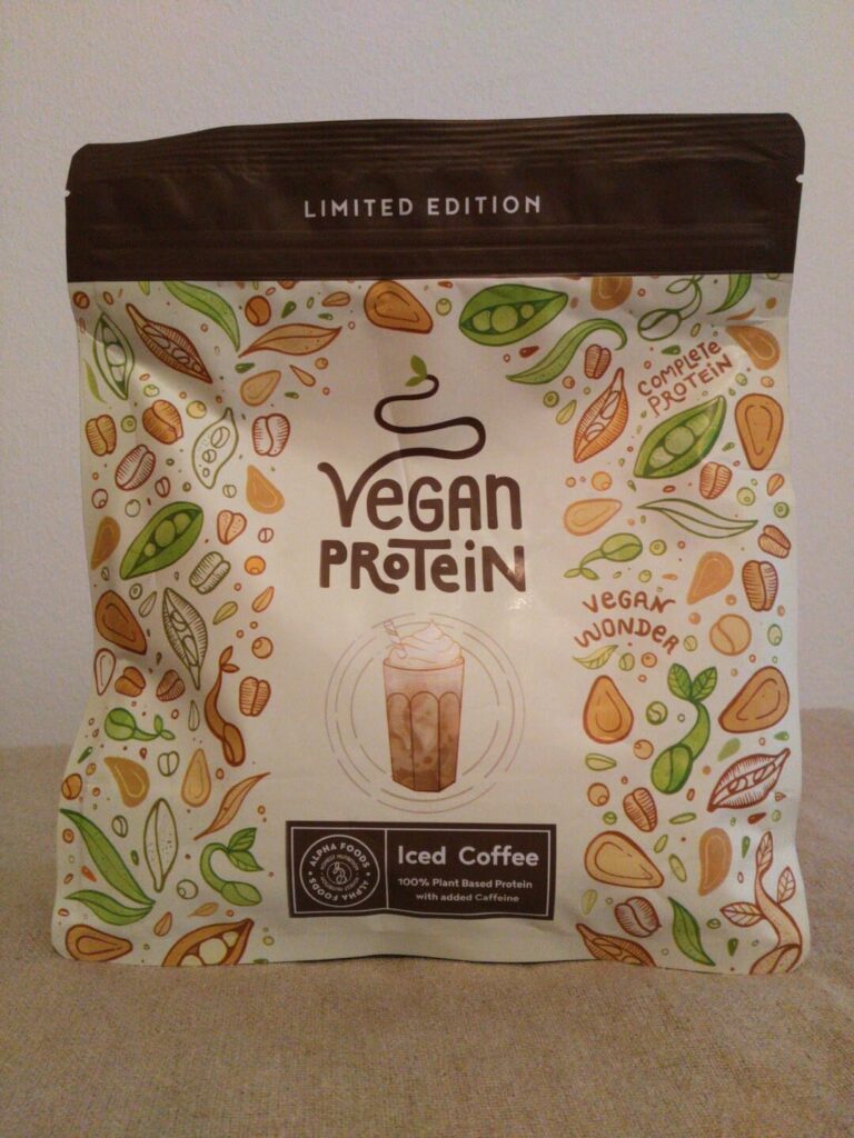 Vue du paquet de protéines vegan saveur café glacé posé sur une surface neutre, à la verticale. Il s'agit du même produit que...