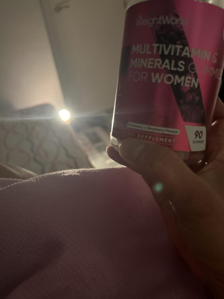 Une personne tient le pot dans sa main, dans un lit. Le pot est penché et flou. On voit la main et le pot sur le côté. Le fon...
