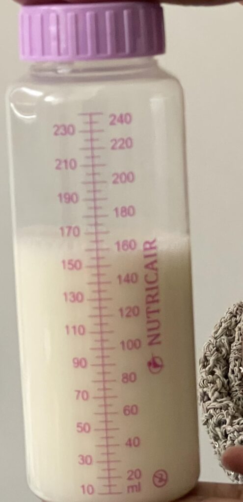 Gros plan sur un biberon avec du lait maternel et des graduations, légèrement différent du visuel 0.