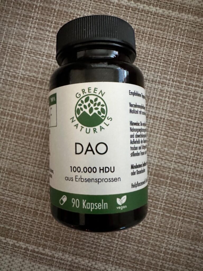 Flacon de capsules DAO posé sur une surface texturée, vu de face. Similaire au visuel 0 mais sans la main.