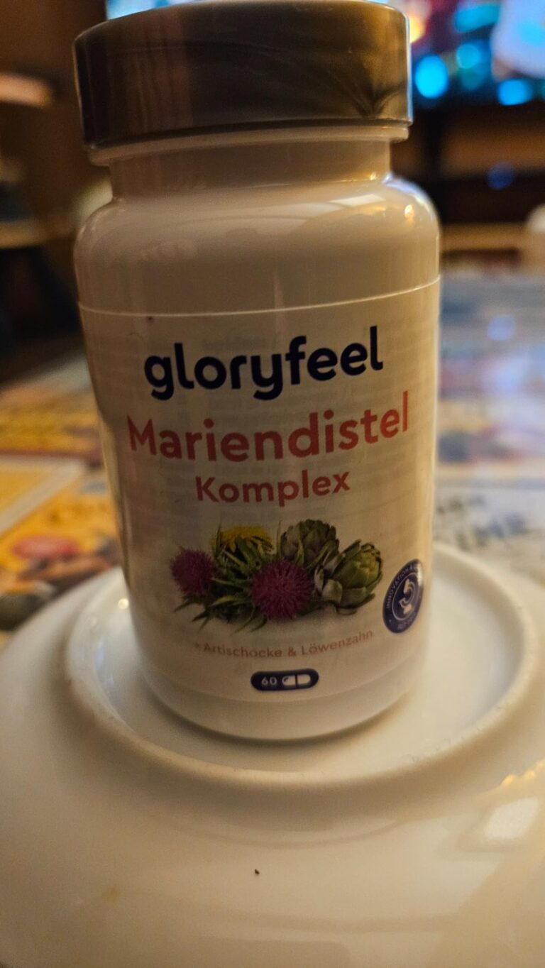 Flacon de compléments alimentaires Mariendistel Komplex de la marque Gloryfeel, de face, posé sur une assiette. Le bouchon es...