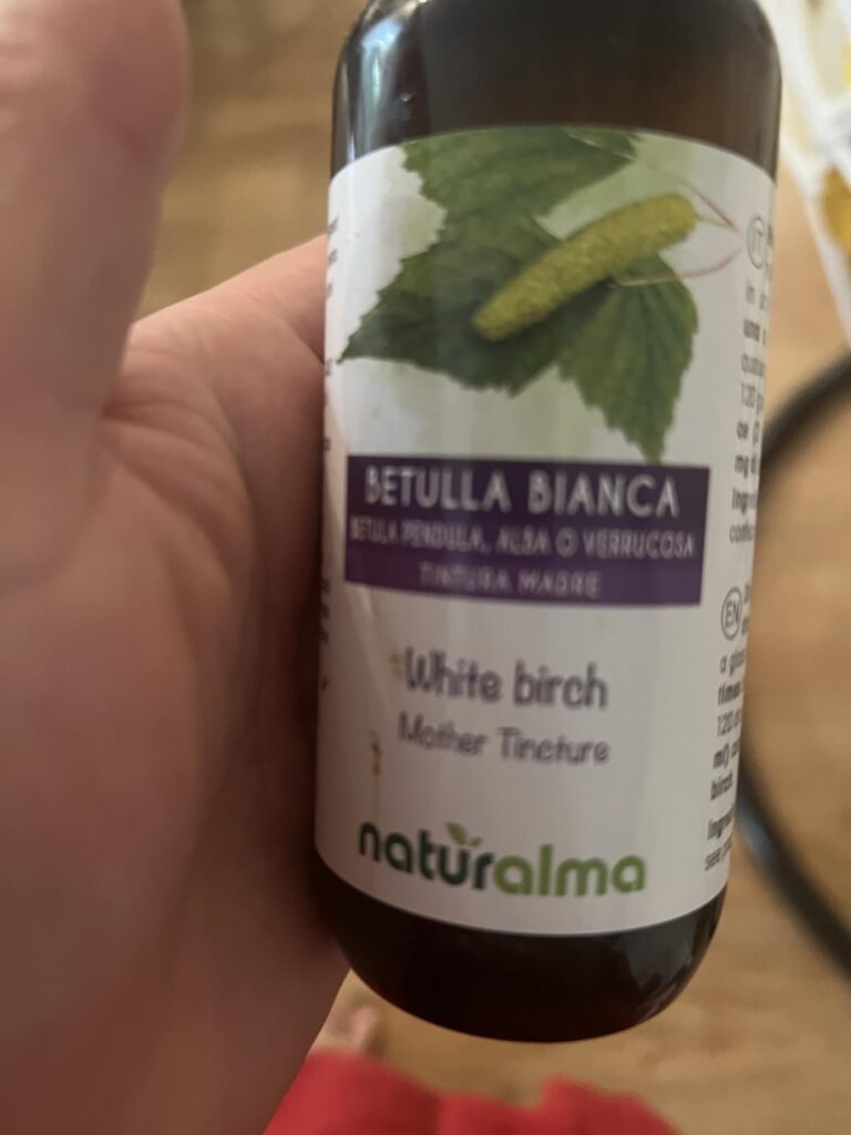Flacon de teinture mère Betulla Bianca tenu dans une main, avec l'étiquette visible.