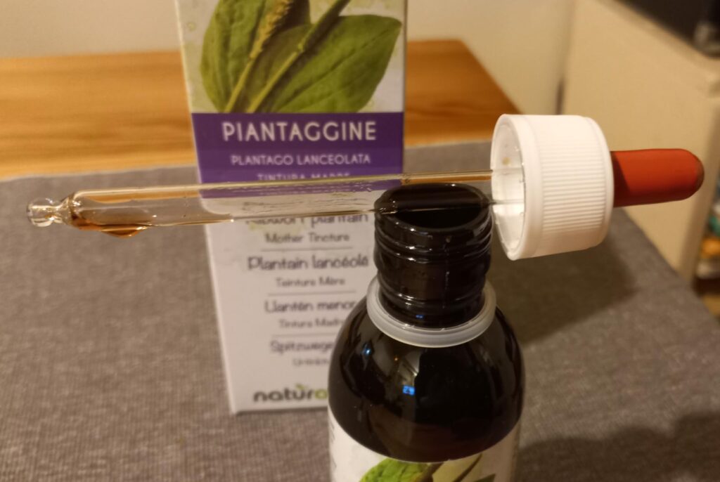 Vue de près du flacon et de sa pipette, avec une goutte de produit au bout de la pipette.