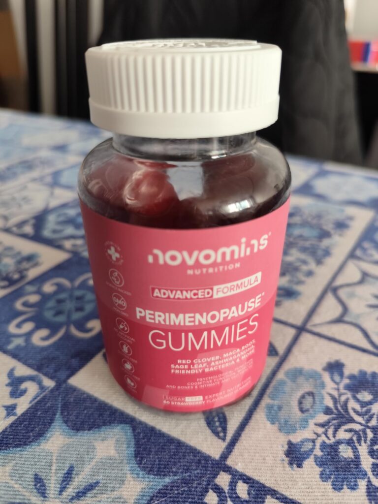 Pot de compléments alimentaires Novomins Nutrition sur une table à carreaux bleus et blancs.