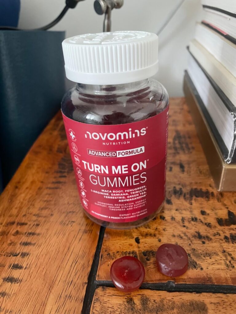 Bocal fermé avec des gommes de vitamines à côté sur une table en bois. Similaire à l'image 0.