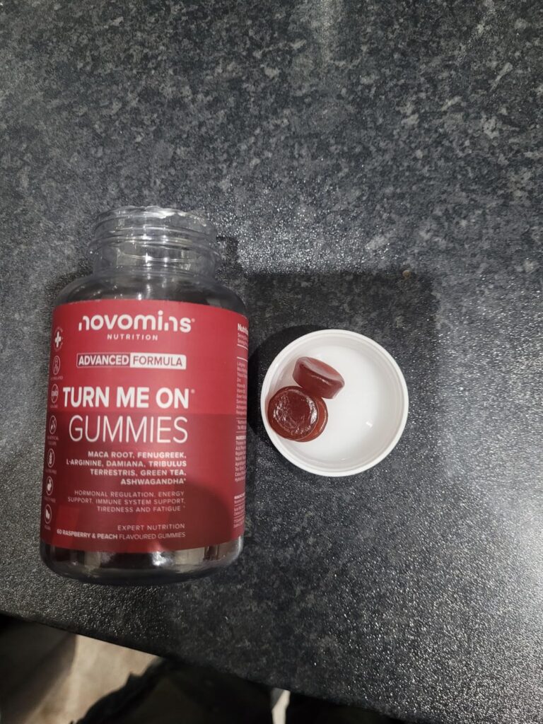 Bocal ouvert avec des gommes de vitamines à côté sur un comptoir.