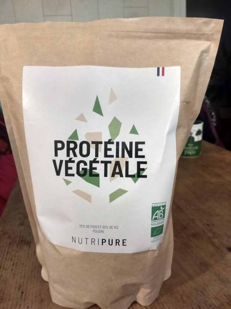 Le sachet de protéines végétales Nutripure en gros plan, posé sur une table en bois.