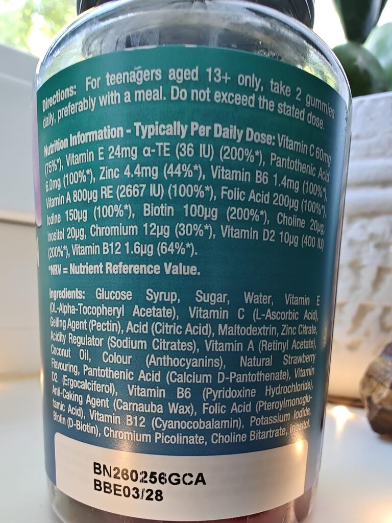 Un gros plan sur l'étiquette au dos d'un pot de vitamines en gomme, détaillant les ingrédients et les valeurs nutritionnelles...