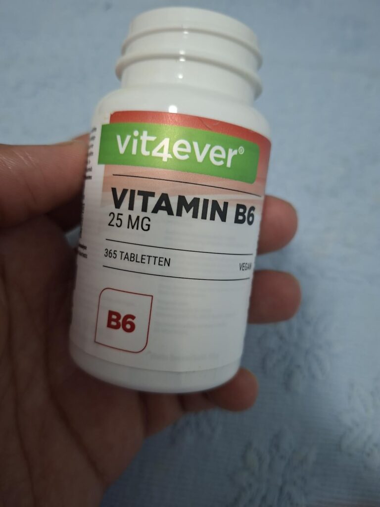 Une main tenant le flacon de Vitamine B6 vit4ever. L'étiquette de devant est visible.