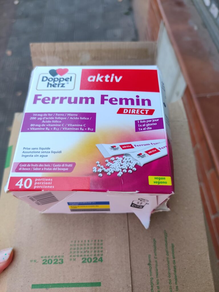 Vue d'ensemble de la boîte de compléments alimentaires posée sur un carton, montrant l'avant de l'emballage.