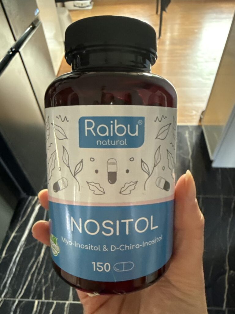 Bouteille de compléments alimentaires tenue dans une main, vue de face.
