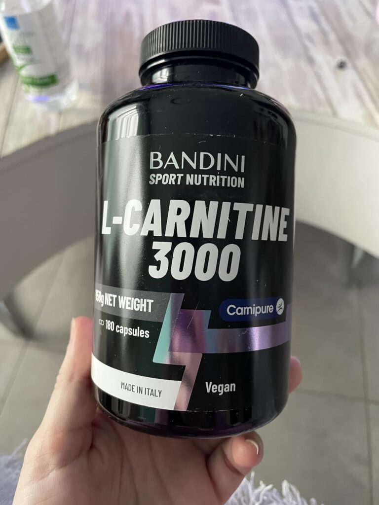 Flacon de L-carnitine 3000 tenu dans une main de femme. Même flacon que visuel 0.