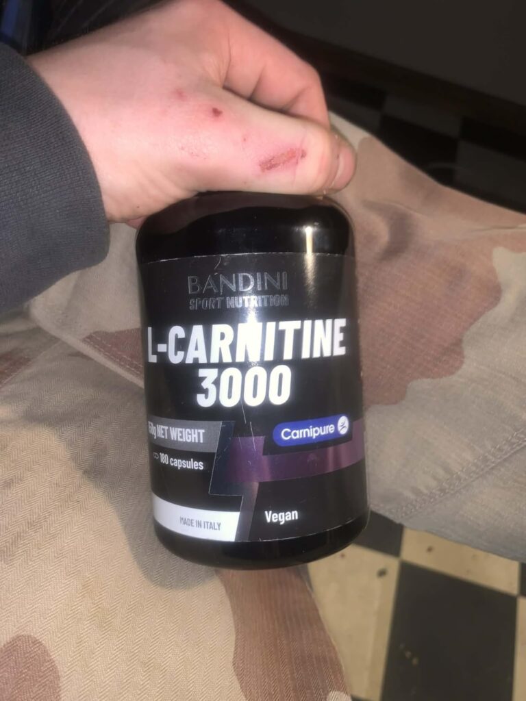 Flacon de L-carnitine 3000 tenu dans une main d'homme. Même flacon que visuel 1.