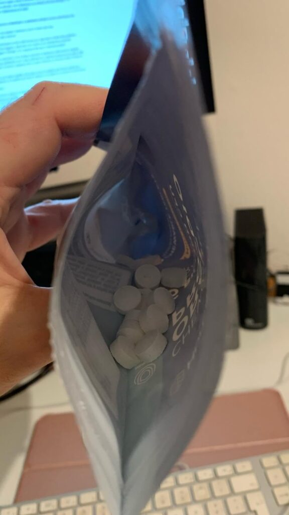 Vue plongeante dans le sachet ouvert, montrant les pastilles à l'intérieur.