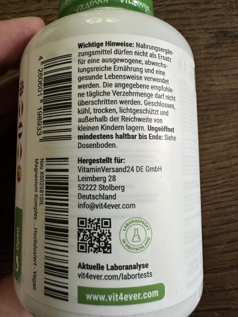 Le dos de la bouteille de compléments alimentaires au magnésium, avec les avertissements légaux, l'adresse du fabricant, et u...