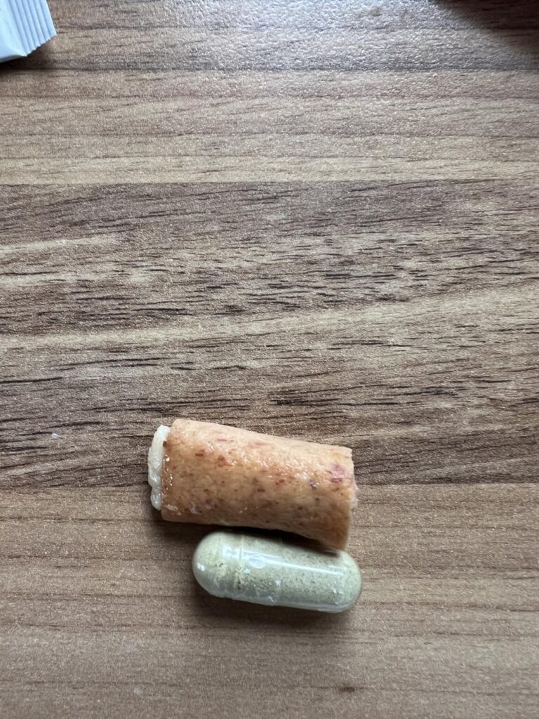 Deux capsules posées sur une table en bois, l'une de couleur marron et l'autre verte.