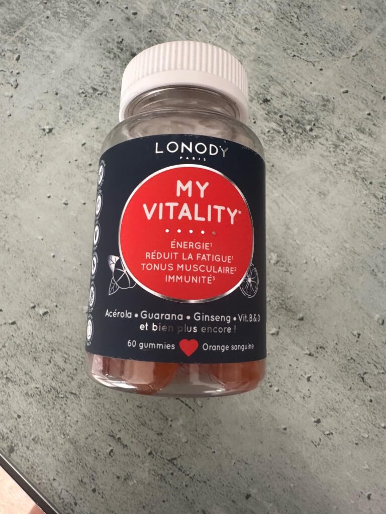 Bouteille de compléments alimentaires, vue de face, sur un fond gris.