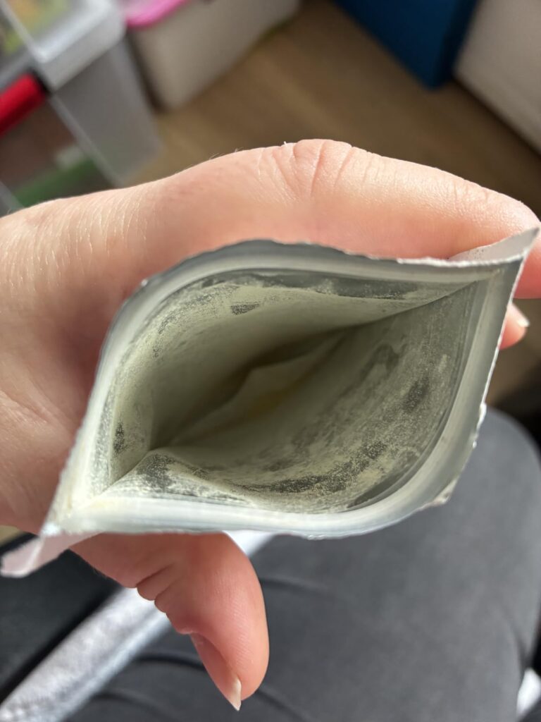 L'intérieur d'un sachet vide, vu de dessus, tenu par une main.