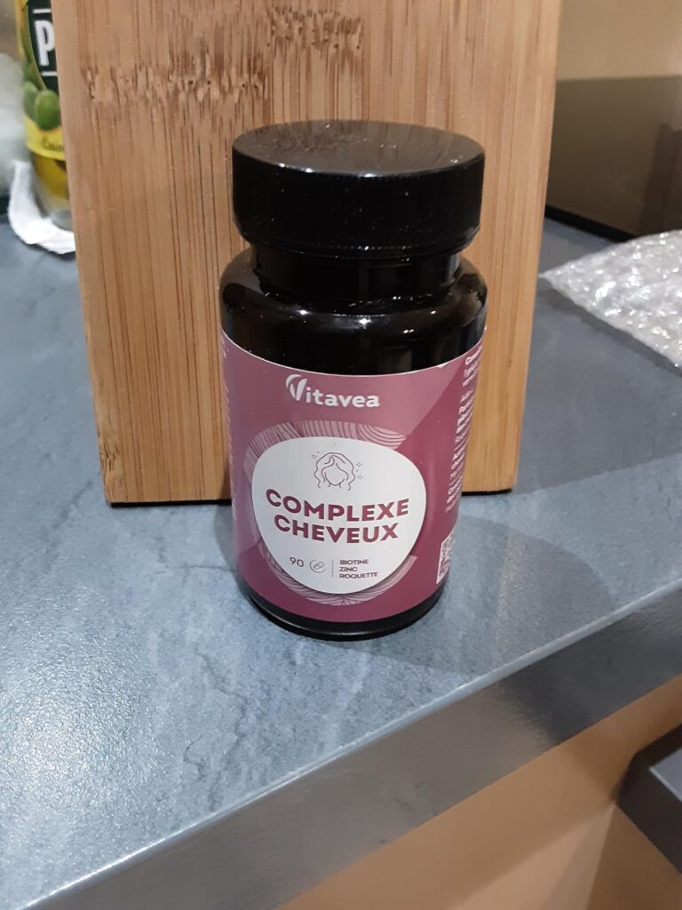 Bouteille du produit sur une table, avec un fond en bois. Montre le même produit que les images 0 et 1.