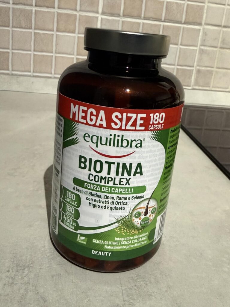 Flacon de compléments alimentaires Biotine Complex posé sur une surface, vue en légère plongée. Il s'agit d'un format plus gr...