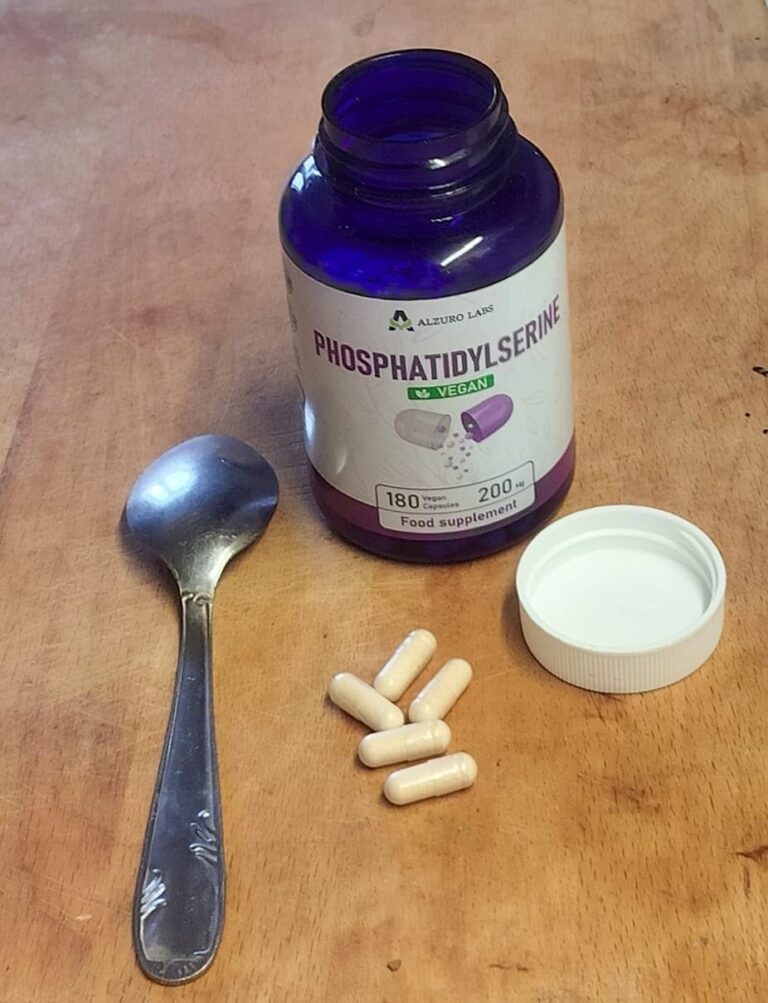 Flacon de Phosphatidylserine ouvert, avec des gélules, une cuillère et le bouchon. Le flacon est en verre teinté bleu.