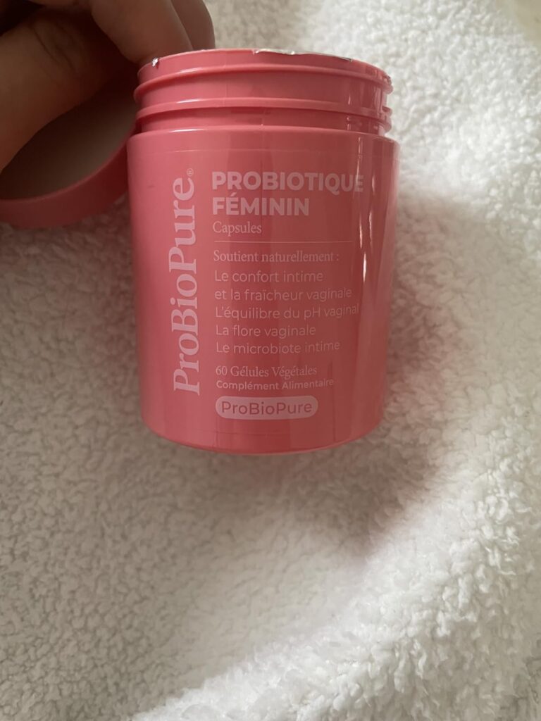 Vue de dessus du pot de probiotiques féminins, bouchon ouvert et décalé sur la gauche. Il y a du texte sur le pot, et le pot...