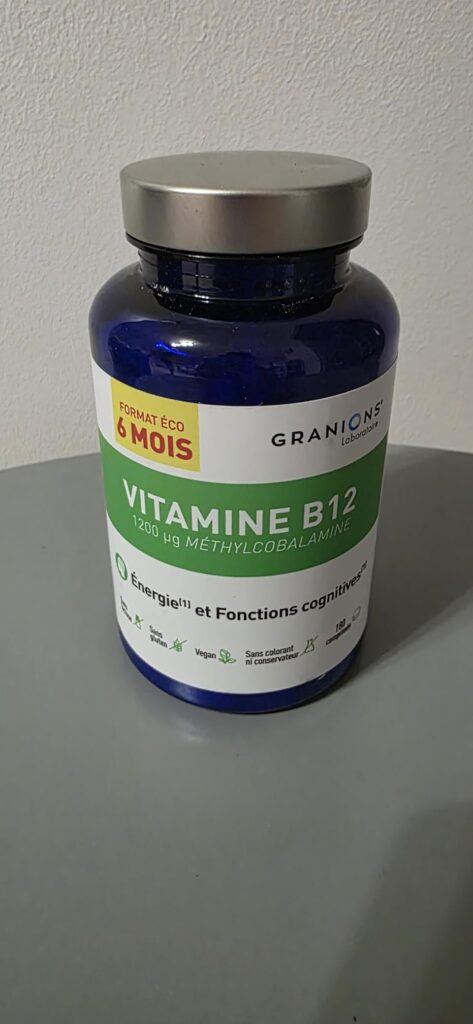 Bouteille de vitamine B12 sur un fond gris neutre.