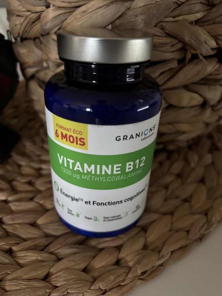 Bouteille de vitamine B12 posée sur un panier en osier, dans un intérieur.