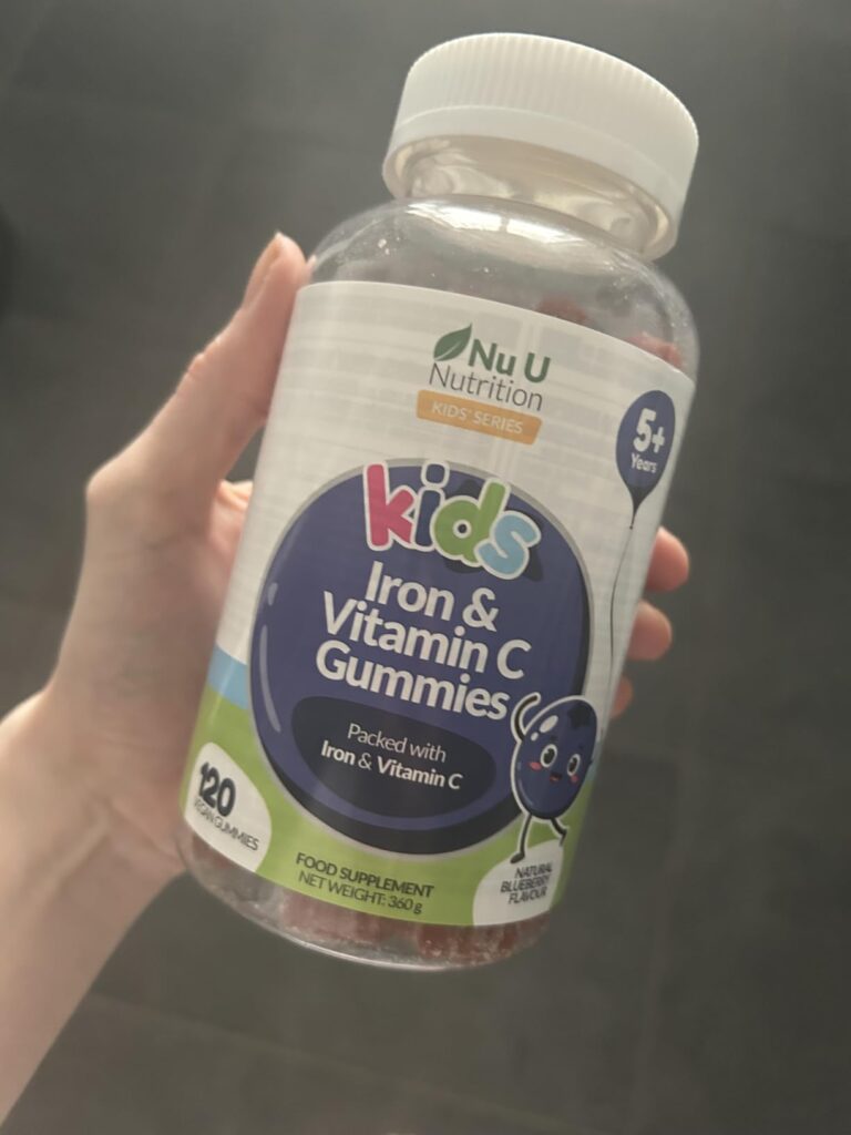 Bouteille de vitamines pour enfants, tenue dans une main, pour donner une idée de la taille. Similaire au visuel 0.