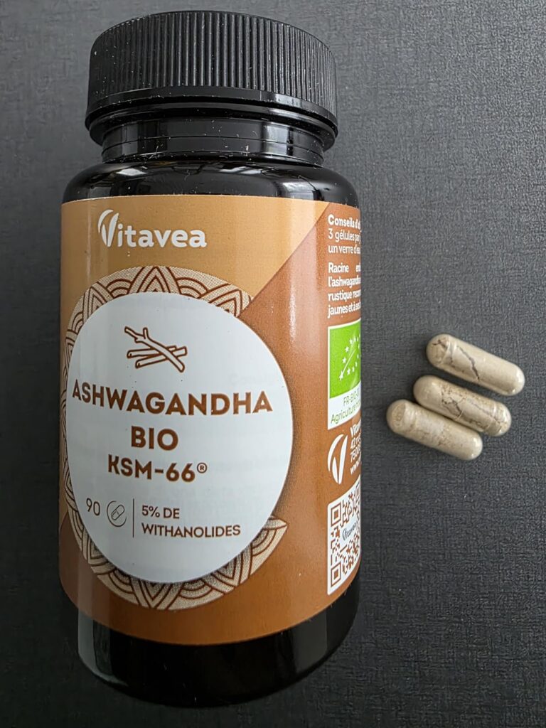 Bouteille d'Ashwagandha Vitavea sur fond noir avec trois gélules à côté.