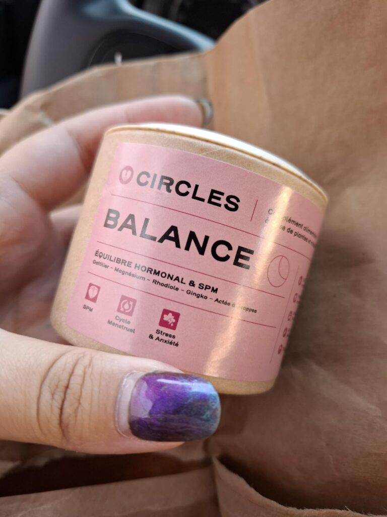 Le produit tenu dans la main, dans un environnement plus naturel (sac en papier en arrière-plan), mettant en évidence l'étiqu...