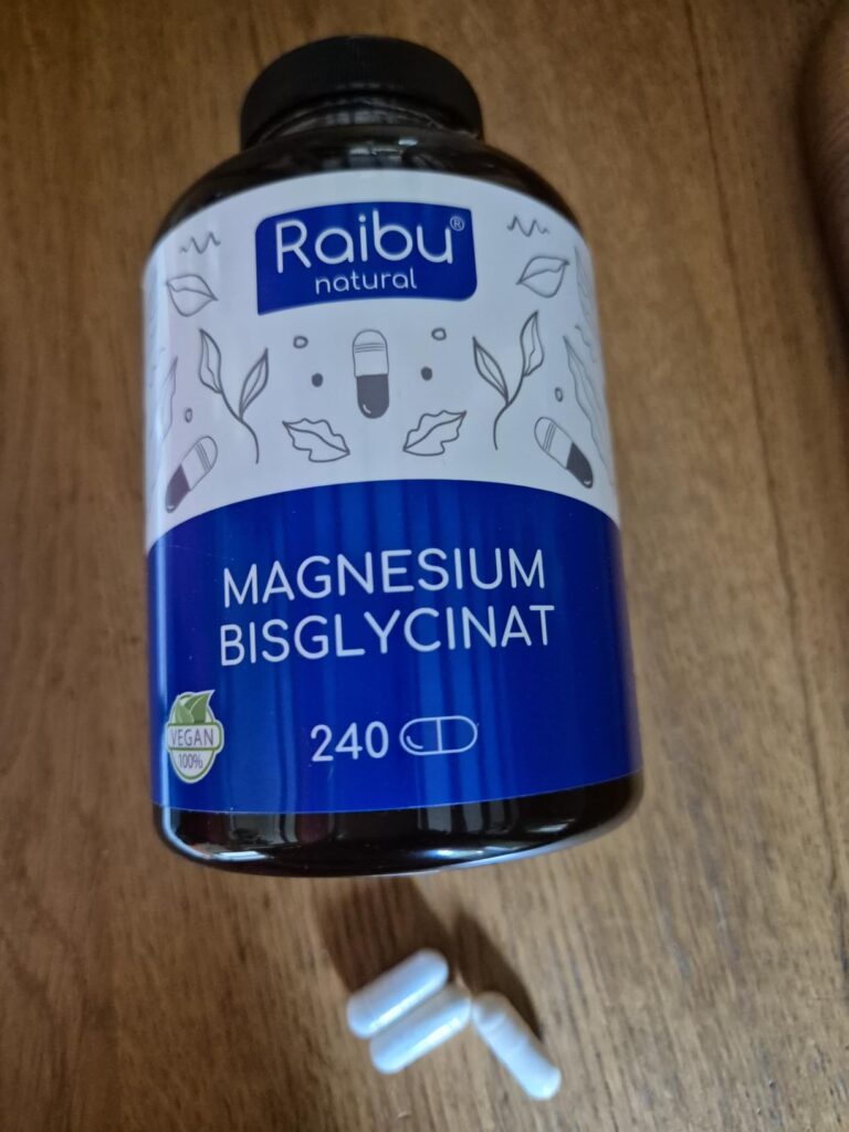 Un flacon de "Raibu natural Magnesium Bisglycinat" avec des gélules éparpillées devant.