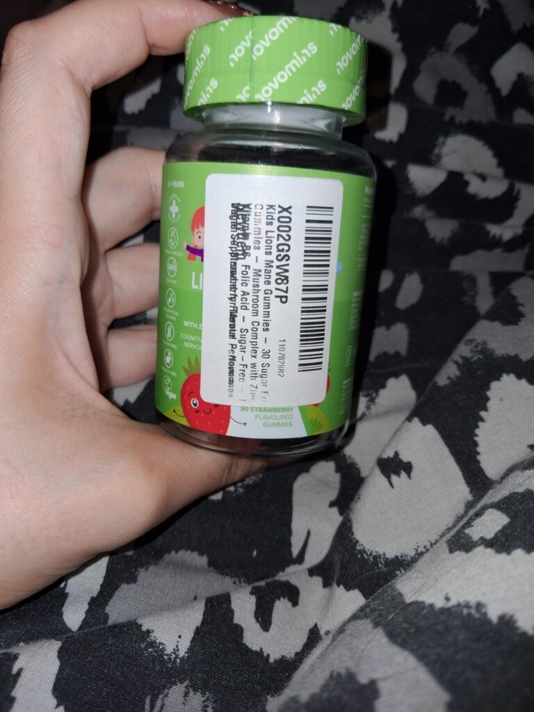 Bouteille de vitamines en gros plan, tenue dans une main, avec l'étiquette code-barres visible
