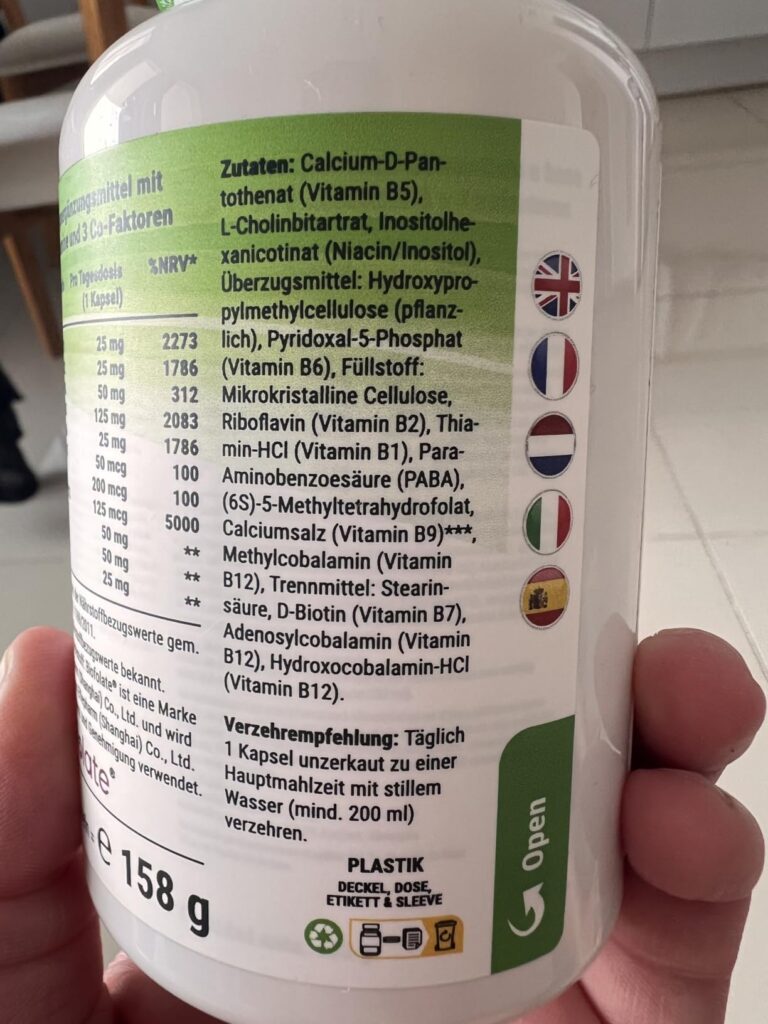 Flacon de compléments alimentaires, face arrière avec les informations diverses et ingrédients, tenu à la main. Identique au...