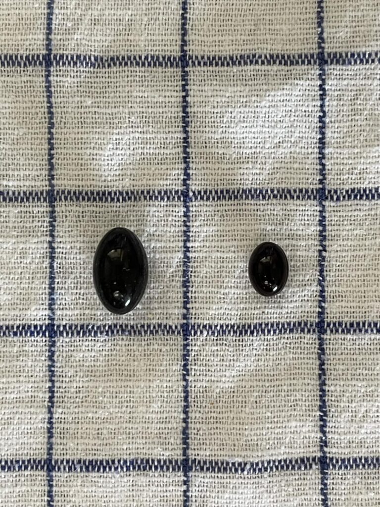 Deux gélules de tailles différentes sur un torchon à carreaux.
