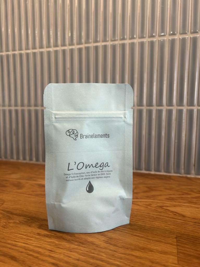 Paquet de compléments alimentaires Brainlements L'Omega posé sur une surface en bois, devant un mur carrelé.