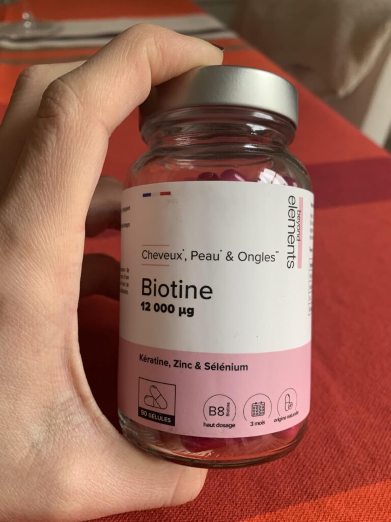 Vue de face du pot de gélules tenu dans une main, montrant l'étiquette principale.
