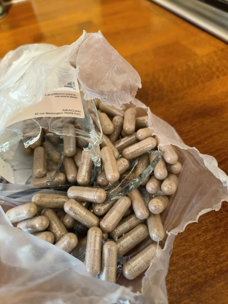 Détail de gélules d'ashwagandha dans un sac en plastique transparent. Vue de près.