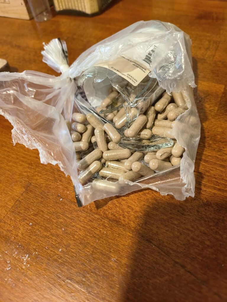 Même vue que le visuel 1, mais légèrement plus éloignée. Détail de gélules d'ashwagandha dans un sac en plastique transparent...